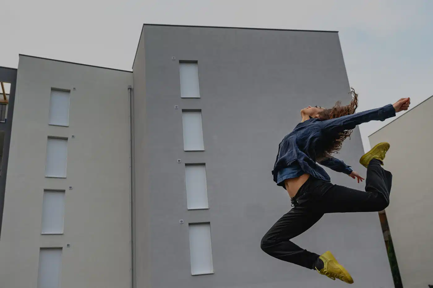 Visuel d’une danseuse se trouvant devant un immeuble de 20 logements collectifs, par Konex ingénierie, pour le projet Cosy.